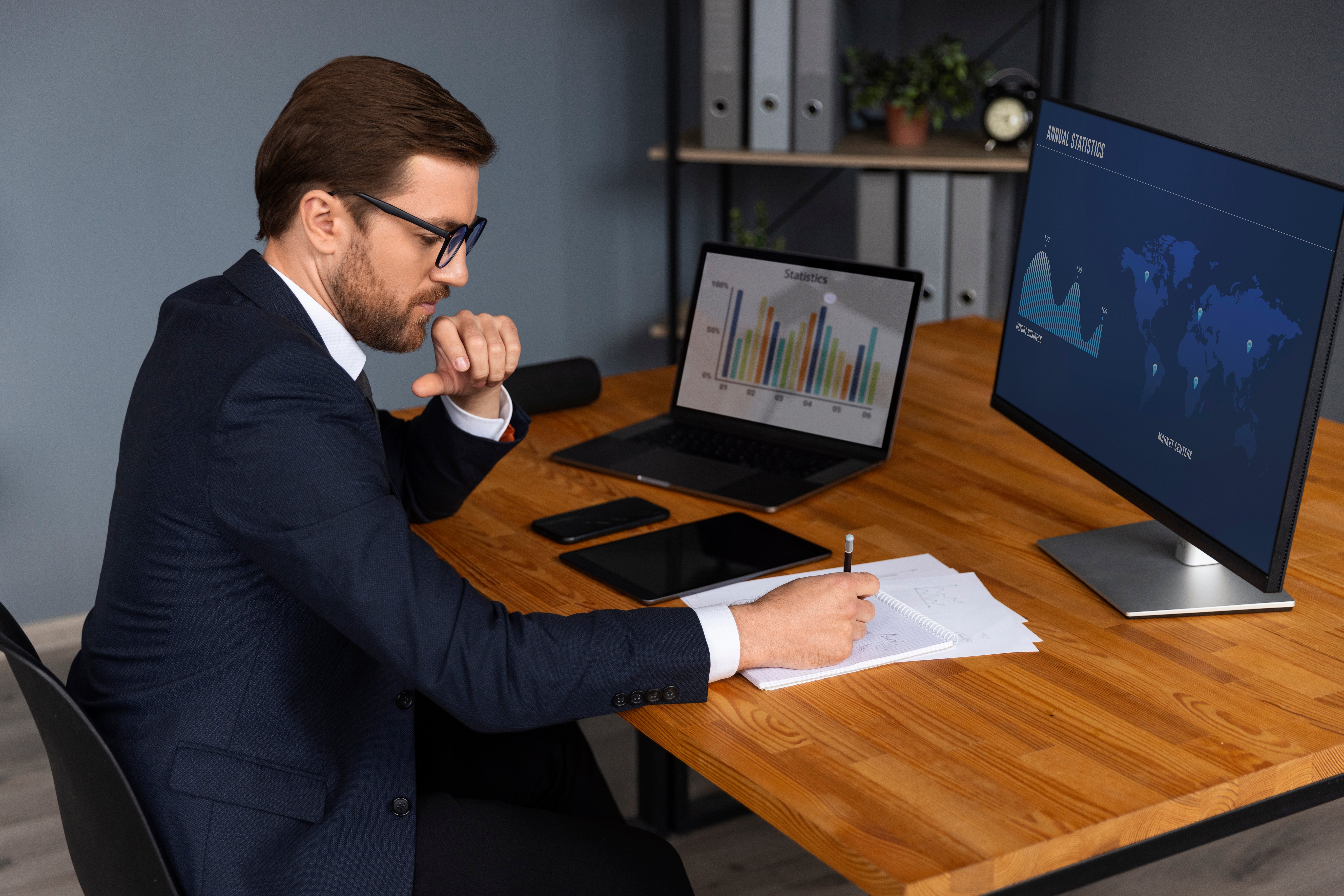Business professional reviewing financial charts on multiple screens, representing key skills taught in MCI Institute’s Accounting and Bookkeeping course