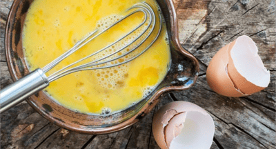 Two eggs cracked into a bowl and whisked