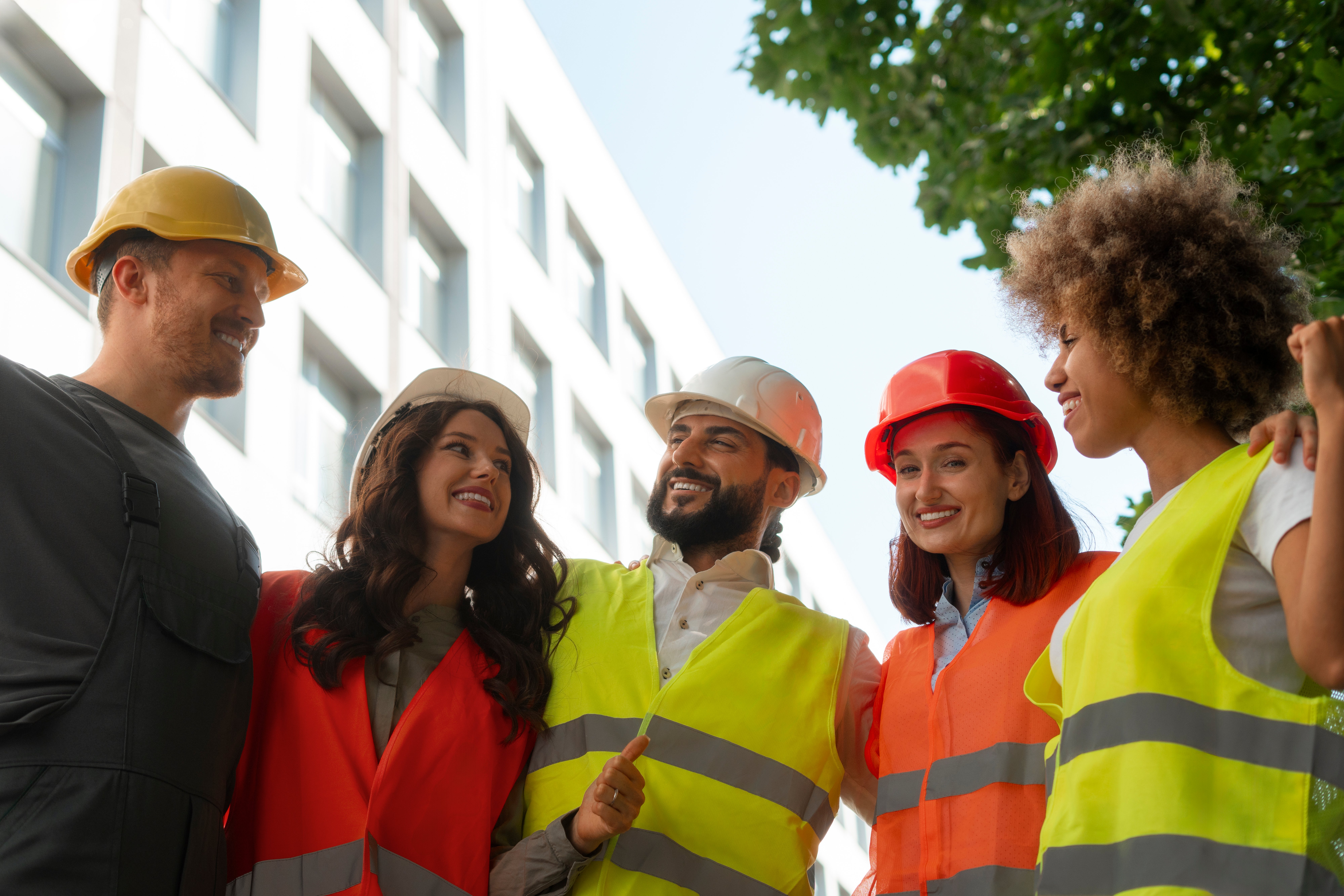 Group of diverse workers in high-visibility vests and hard hats, highlighting the importance of safety leadership and WHS careers in 2025