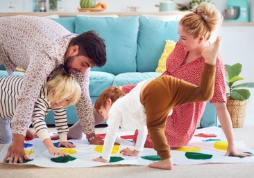 happy family having fun together, playing twister game at home